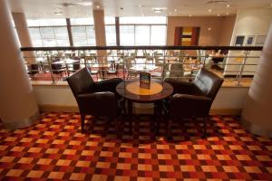 a restaurant with a table and chairs and a cafeteria at Britannia Hotel Bolton in Bolton