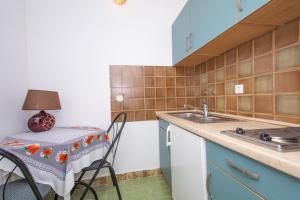 トロギールにあるApartmani Cubelaのテーブルとシンクのある小さなキッチン
