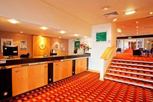 a lobby with a waiting area and stairs in a hospital at Britannia Hotel Bolton in Bolton