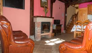 sala de estar con 2 sillas y chimenea en Casa Rural La Torre de Espinama, en Espinama