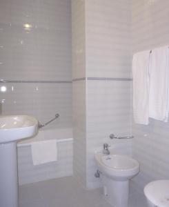 a white bathroom with a sink and a toilet at Hotel Picos de Europa in Arenas de Cabrales