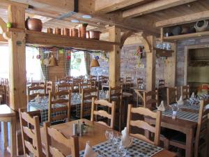 een eetkamer met houten tafels en stoelen bij Auberge des Skieurs in La Bresse