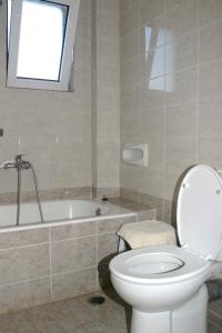 a bathroom with a toilet and a bath tub at Oasis Guesthouse in Chania Town