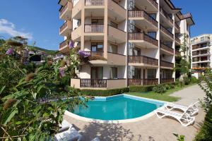 an apartment building with a swimming pool in front of it at Mars Apartments in Complex Shipka in Sveti Vlas