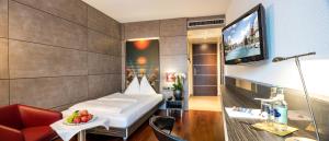 a hotel room with a bed and a tv at Hotel Sternen Oerlikon in Zurich