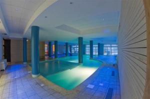 een groot zwembad in een groot gebouw bij Noemys Terrasses de Labrau in La Foux