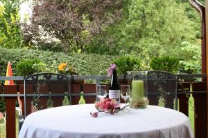 a table with a bottle of wine and two glasses at Haus Schwalbennest in Undeloh