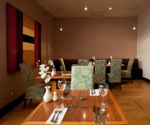 a dining room with a wooden table and chairs at Britannia Hotel Bolton in Bolton
