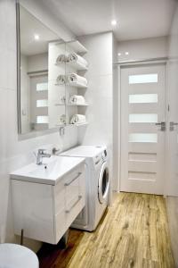 biała łazienka z pralką i umywalką w obiekcie Apartament Fryderyk Premium 2 w Nysie