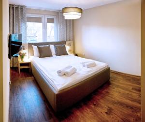 sypialnia z dużym łóżkiem z ręcznikami w obiekcie Apartament Fryderyk Premium 2 w Nysie