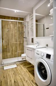 a bathroom with a washing machine and a shower at Apartament Fryderyk Premium 2 in Nysa