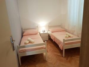 2 łóżka pojedyncze w małym pokoju z lampką w obiekcie Apartment Vice mali w Splicie