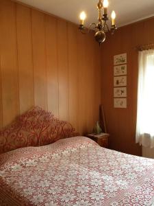 a bedroom with a bed with a red and white bedspread at Villa Wanda in Cavalese