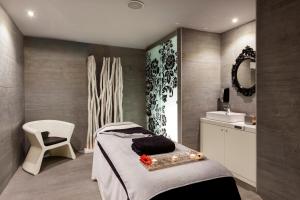 a bedroom with a bed and a chair and a sink at Barceló Teguise Beach - Adults Only in Costa Teguise