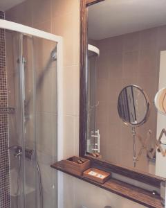 uma casa de banho com um chuveiro e um espelho. em Apartments Legacy em Belgrado