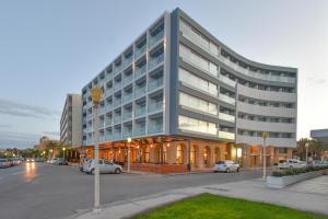a large building with cars parked in a parking lot at Ibiscus Hotel in Rhodes Town
