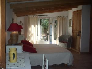 Schlafzimmer mit einem Bett und einer Tür zu einer Terrasse in der Unterkunft Gîte Saint-Veredeme in Pujaut