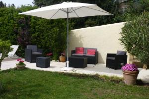 eine Gruppe Stühle und ein Sonnenschirm auf einer Terrasse in der Unterkunft Gîte Saint-Veredeme in Pujaut