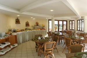 a restaurant with tables and chairs and a buffet at Divi-Divi Praia Hotel in Natal