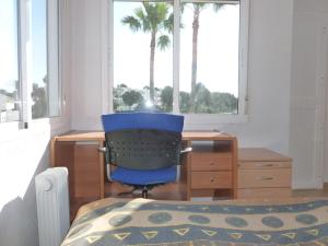 niebieskie krzesło siedzące przy biurku przed oknem w obiekcie Appartement Penthouse II 15 - 5 w mieście Mijas Costa