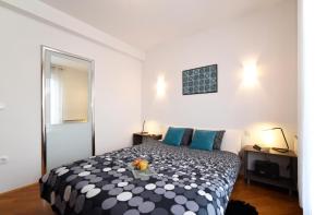 una camera da letto con un letto bianco e nero con cuscini blu di Corner Apartment a Zagabria