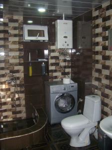 a bathroom with a toilet and a washing machine at Downtown guest house in Kutaisi