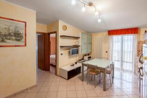 a kitchen and dining room with a table and a desk at Palazzo Giallo in Alba Adriatica