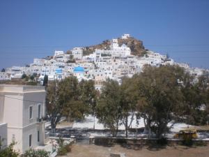 a town on top of a hill with trees at Armonia Pension in Ios Chora