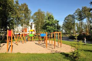 ein Spielplatz mit bunten Geräten in einem Park in der Unterkunft Apartament Kristina Osiedle Polanki in Kołobrzeg