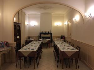 a dining room with tables and chairs and an archway at Hotel Acapulco in Montpellier