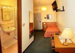 a bathroom with a bedroom with a bed and a sink at Hotel Bottaccio in Frascati