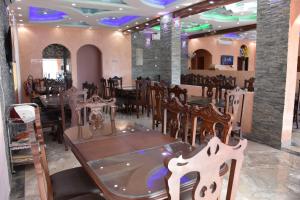 a restaurant with tables and chairs in a room at Green Mountain Hotel Apartments in Al ‘Aqar