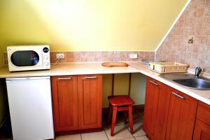 a small kitchen with a microwave and a sink at Domek u Darka in Kielce