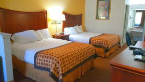 a hotel room with two beds and a desk at Americas Best Value Inn & Suites Fort Worth South in Fort Worth +4 photos