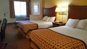 a hotel room with two beds and a room with two lamps at Americas Best Value Inn & Suites Fort Worth South in Fort Worth