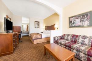 a hotel room with a couch and a bed at Americas Best Value Inn & Suites Fort Worth South in Fort Worth