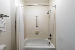 a white bathroom with a tub and a shower at Americas Best Value Inn & Suites Fort Worth South in Fort Worth