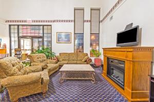 a living room with a fireplace and a tv at Americas Best Value Inn & Suites Fort Worth South in Fort Worth