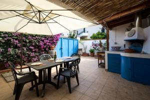 una mesa y sillas con sombrilla en la cocina en Domus Sicily - Villa Onda en Mondello