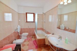 a bathroom with a sink and a toilet and a tub at Garden Apartment Maria in Vrsar +23 photos