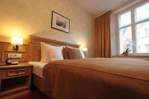 Postel nebo postele na pokoji v ubytování Romantik Hotel Scheelehof Stralsund