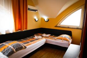two beds in a small room with a window at Princess Apartman in Siófok +31 photos