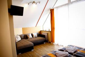 sala de estar con sofá y TV en Princess Apartman, en Siófok