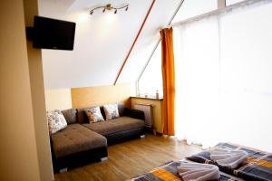 a living room with a couch and a tv at Princess Apartman in Siófok