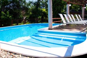 a group of chairs sitting next to a swimming pool at Princess Apartman in Siófok