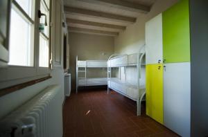 a room with two bunk beds and a window at Ostello San Miniato in San Miniato