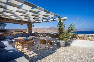 a patio with a blue couch and a table at Myconian Platinum Villas in Kalafatis