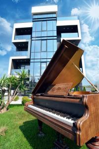 ママイア・ノルドにあるImperia by Zev Apartmentsの建物前の芝生に座るピアノ