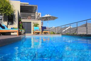 クニスナにあるBrenton Haven Beachfront Resortの家の隣にある傘付きのスイミングプール