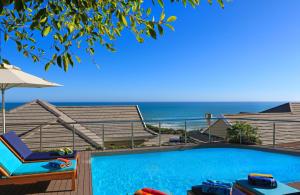a swimming pool with a view of the ocean at Brenton Haven Beachfront Resort in Knysna